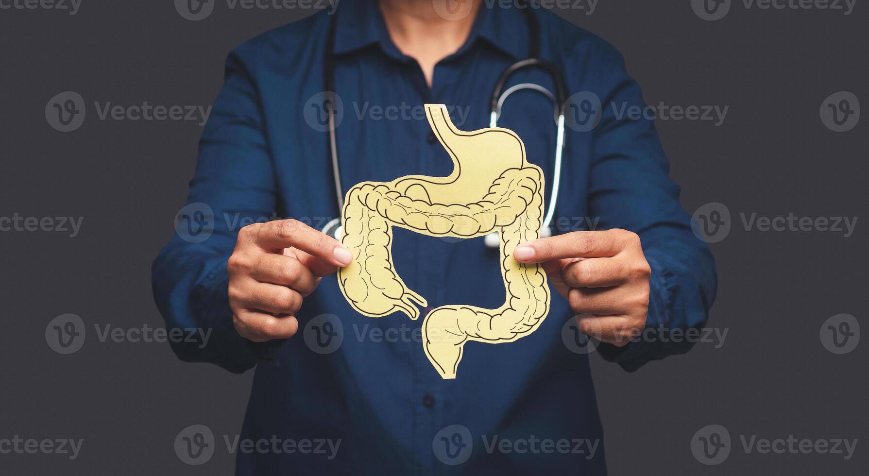 Hand of the doctor holding a colon symbol while standing on a gray background photo