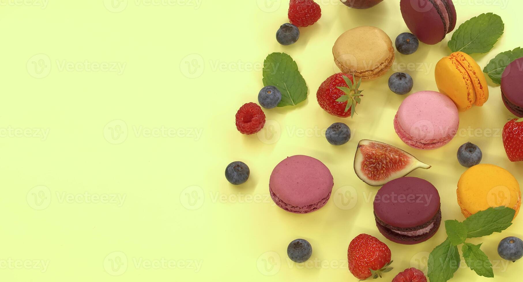 Table filled with array of macaroons and fruits photo