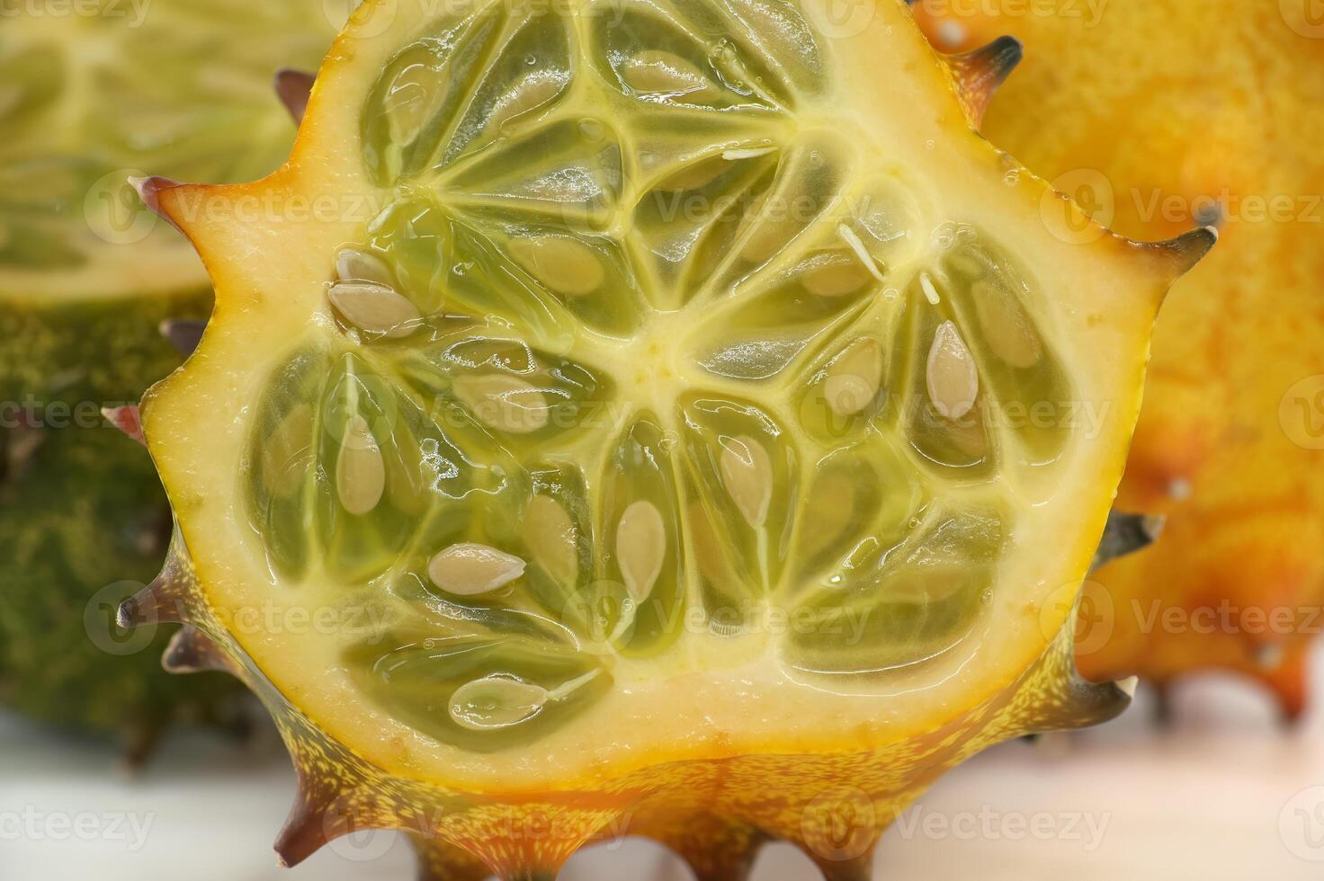 A close-up shot of horned melon highlighting its vibrant green interior and textured orange exterior photo