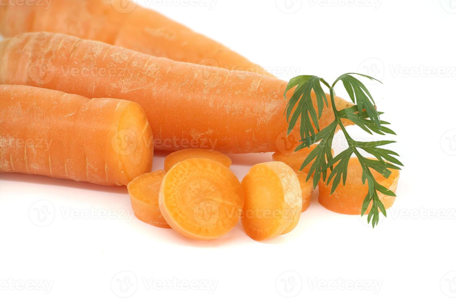 Close-Up of Fresh Orange Carrots With Slices and Green Leaves on White Background photo