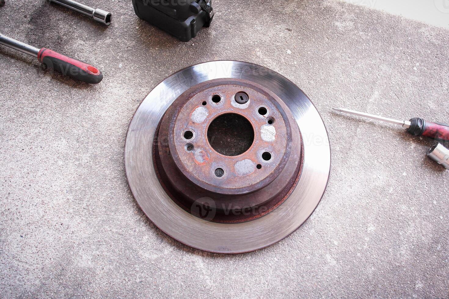 Close up of rusty brake disc of car with tools , Automotive parts concept photo