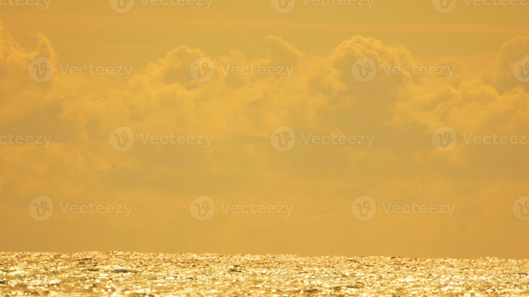 Sky Clouds Ocean - Golden Sunset Over Water with Hazy Sky photo