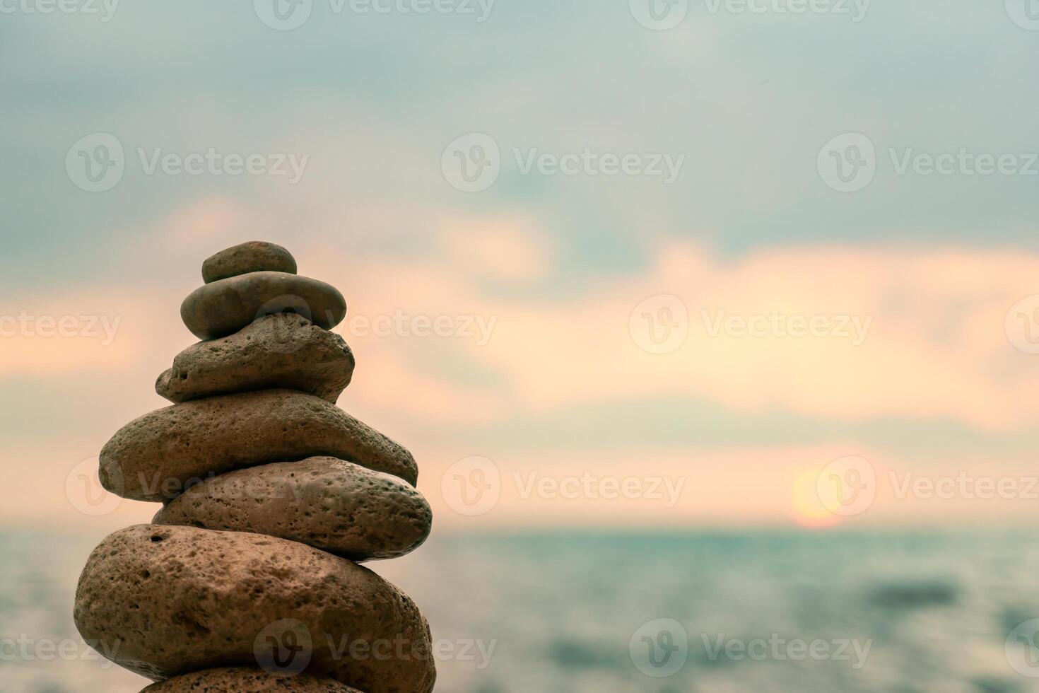 Stones Stack Beach Sunset - Balanced stones tower on a beach with a cloudy sunset in the background. photo
