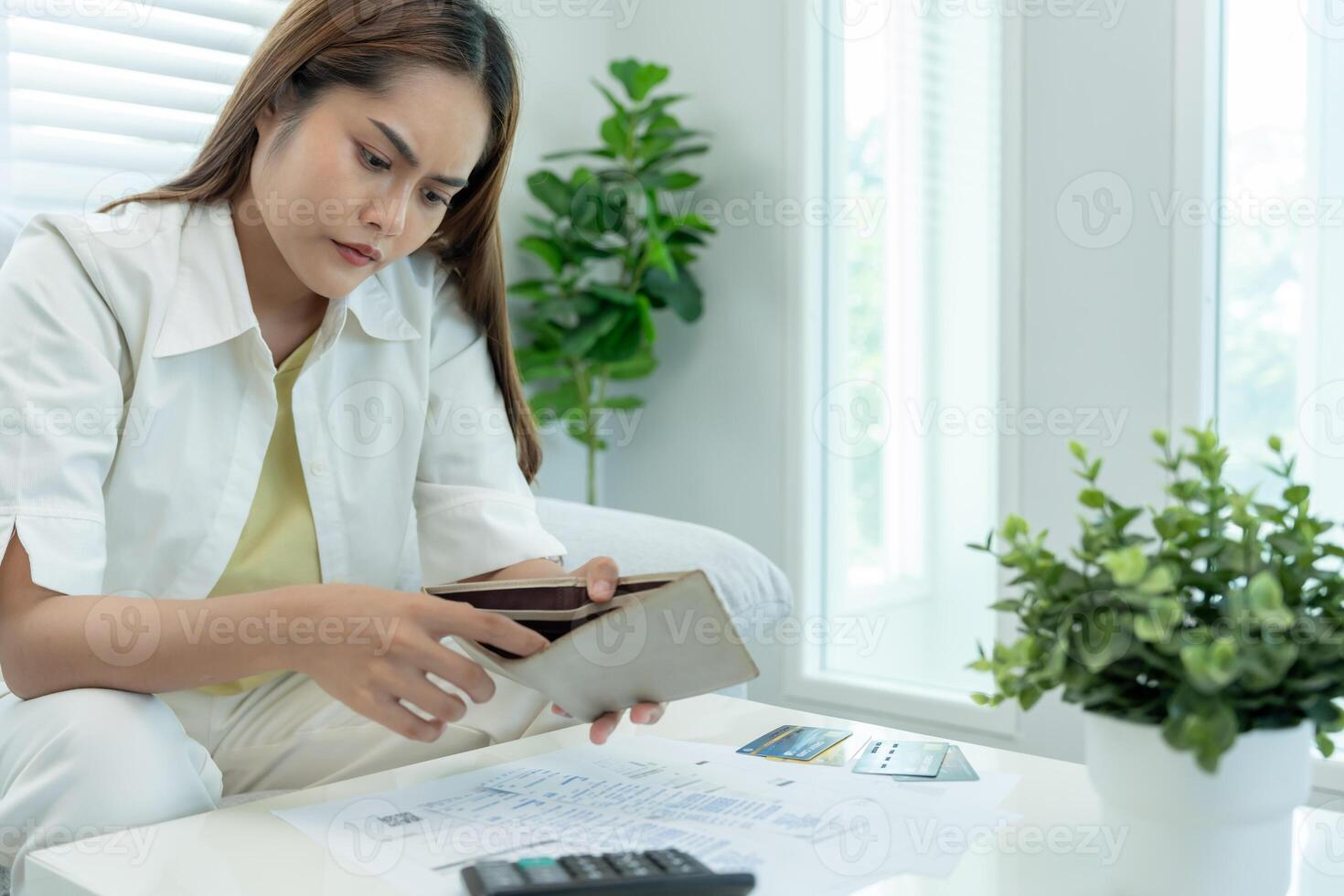 Stressed and headache asian woman with large bills or invoices no money to pay to expenses and credit card debt. shortage, Financial problems, mortgage, loan, bankruptcy, bankrupt, poor, empty wallet photo