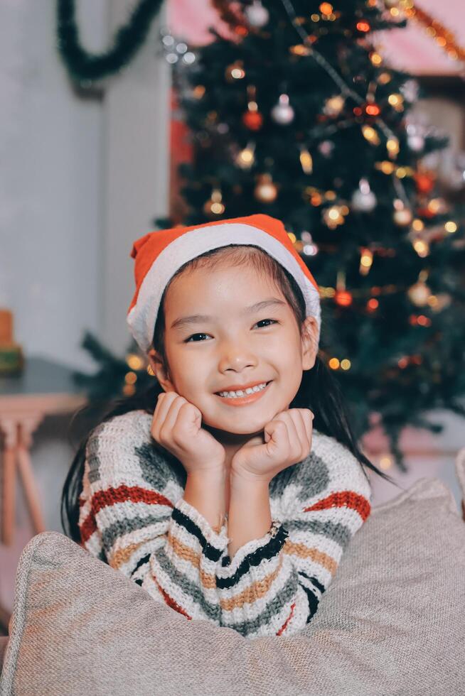 christmas, x-mas, winter, happiness concept - dreaming girl in santa helper hat photo