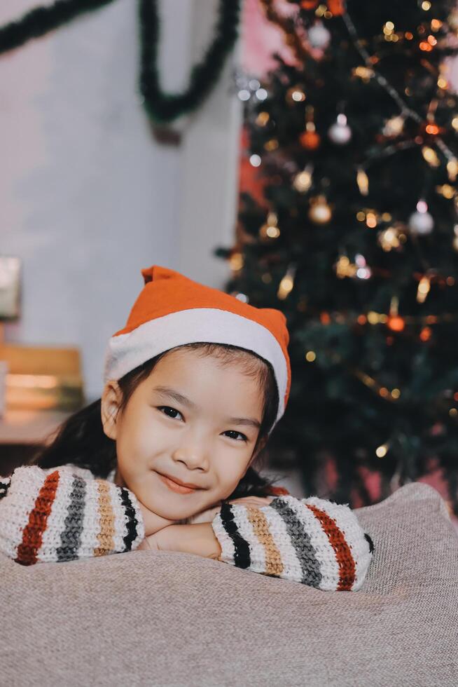 christmas, x-mas, winter, happiness concept - dreaming girl in santa helper hat photo
