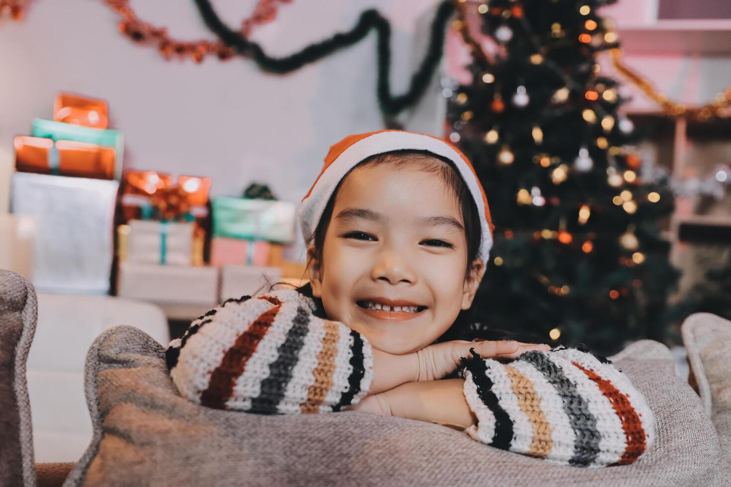 christmas, x-mas, winter, happiness concept - dreaming girl in santa helper hat photo