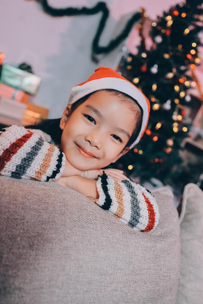 christmas, x-mas, winter, happiness concept - dreaming girl in santa helper hat photo