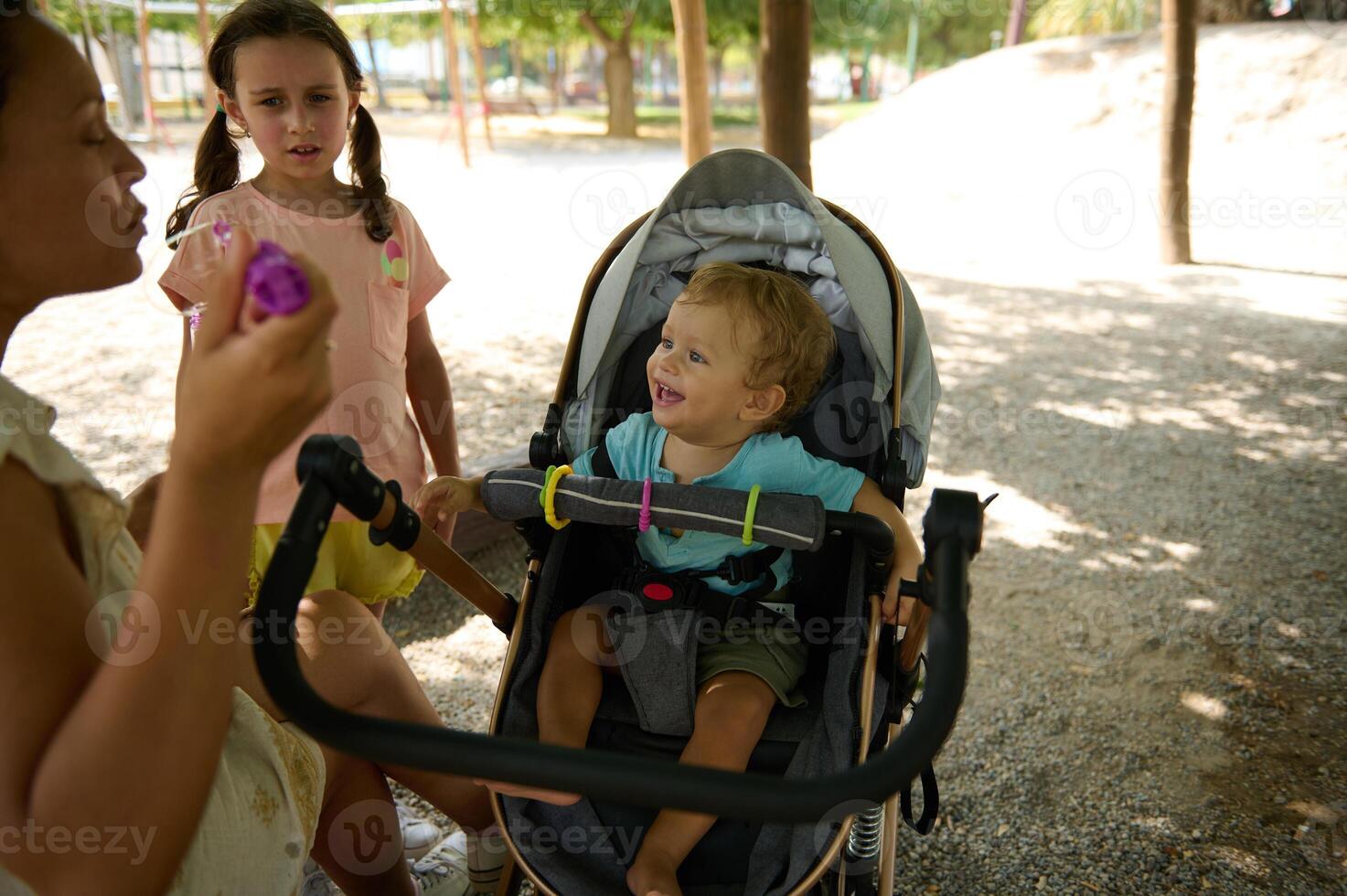 Family outing at the park with children and a stroller on a sunny day photo