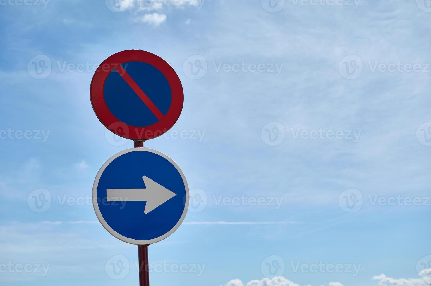Traffic signs indicating no parking and right turn against blue sky photo