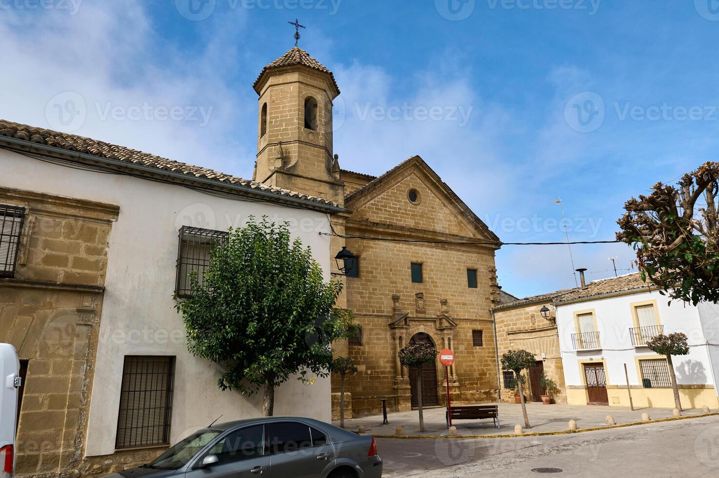 Historic European church facade in a quiet village square under blue sky photo