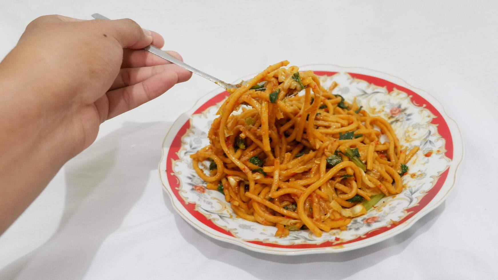person holding a plate of noodles, food from Indonesia, gomak noodles photo