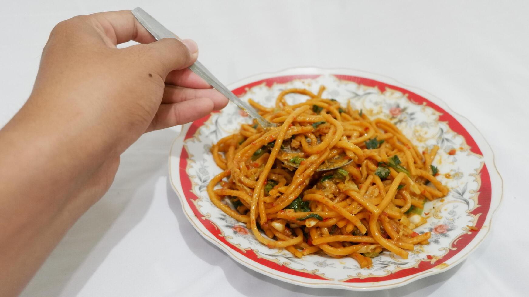 person holding a bowl of noodles photo