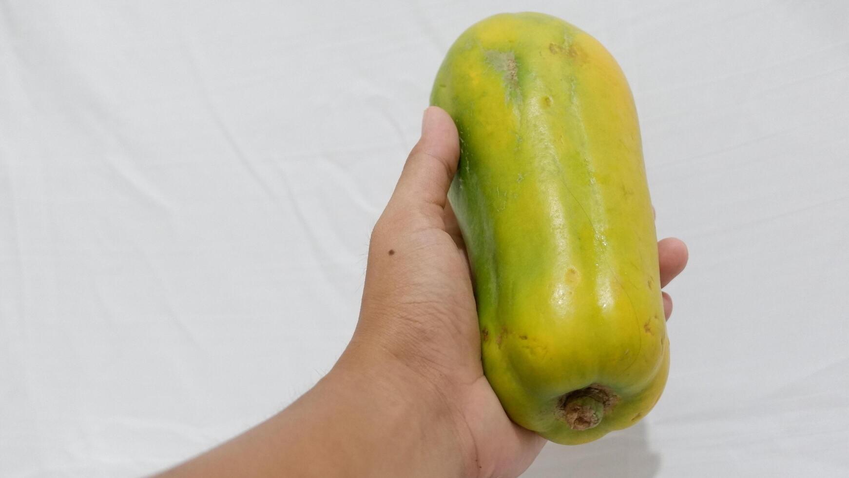 hand holding a bunch of yellow papaya photo