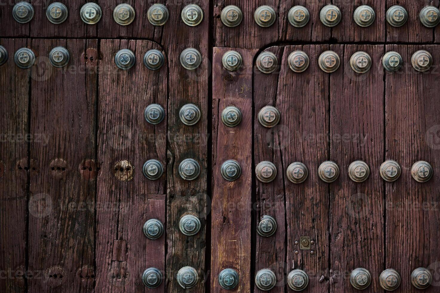 Close-up of ornate wooden medieval door with metal studs and texture photo