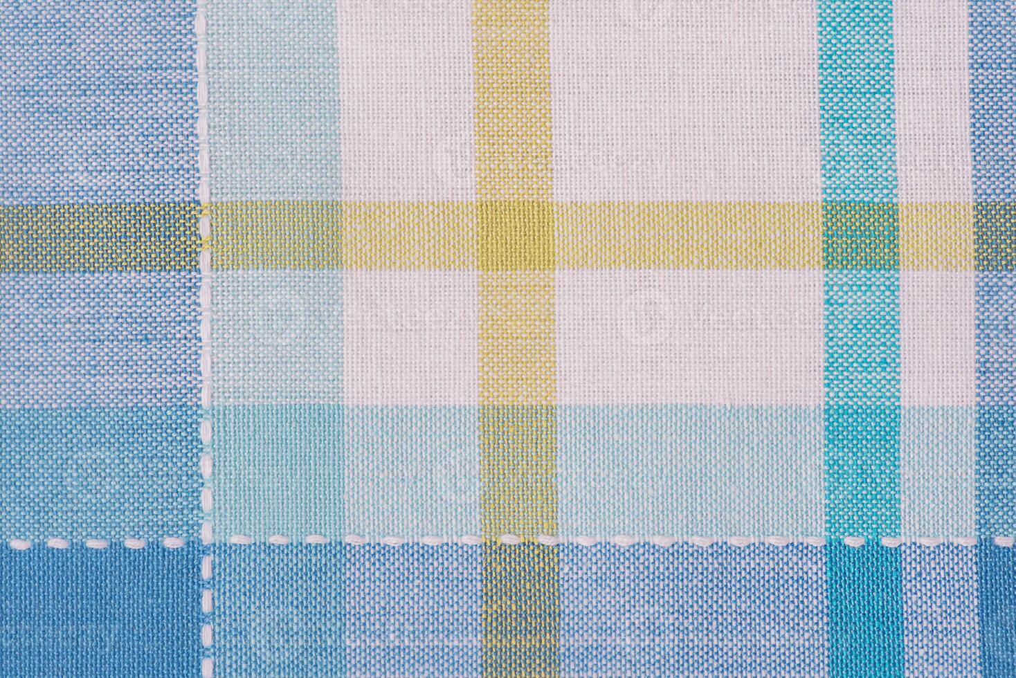 Checkered blue with yellow and white color fabric background. photo