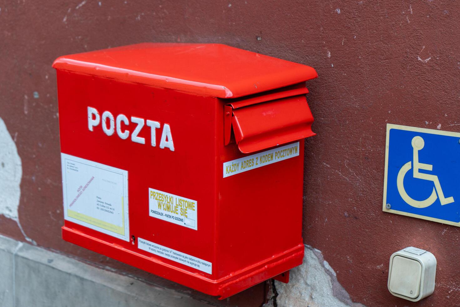 Polish red mailbox on the street. Box for letters and correspondence. Warsaw, Poland - July 23, 2023. photo