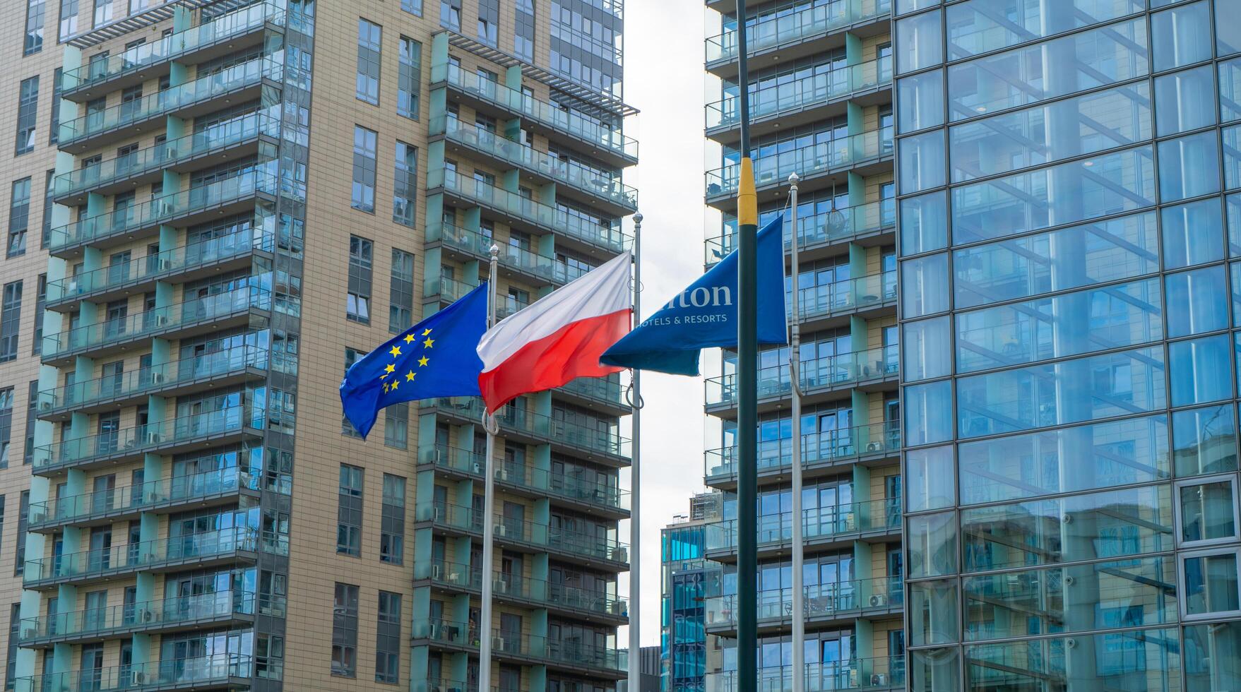The building and logo of the Polish hotel Hilton Warsaw. Office building skyscraper in the city center. Warsaw, Poland - July 26, 2023. photo
