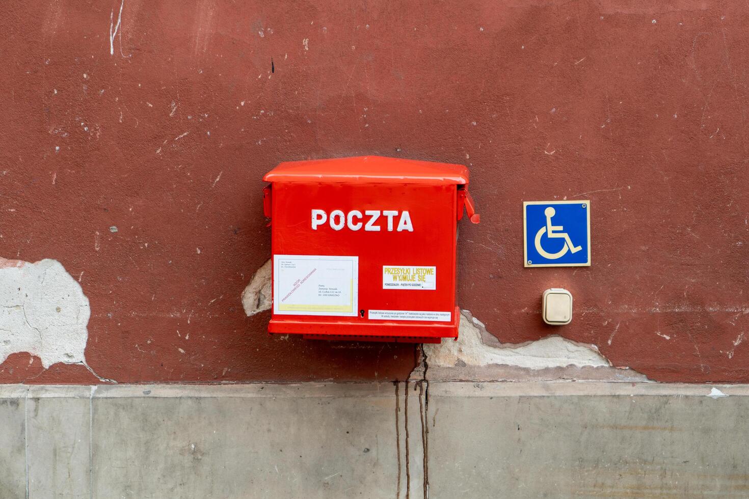 Polish red mailbox on the street. Box for letters and correspondence. Warsaw, Poland - July 23, 2023. photo