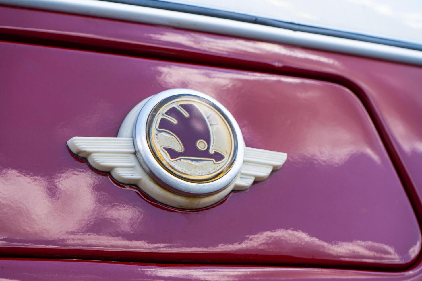 The old red Skoda bus logo sign. Purple vintage model. photo