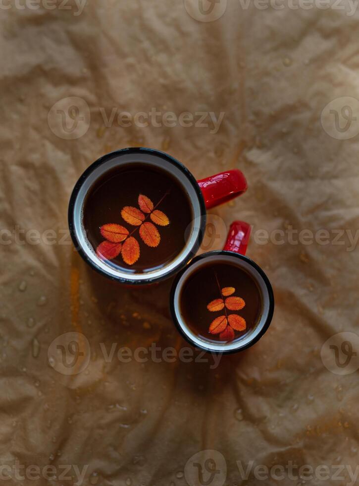 two mugs of tea, an autumn leaf in the mug photo