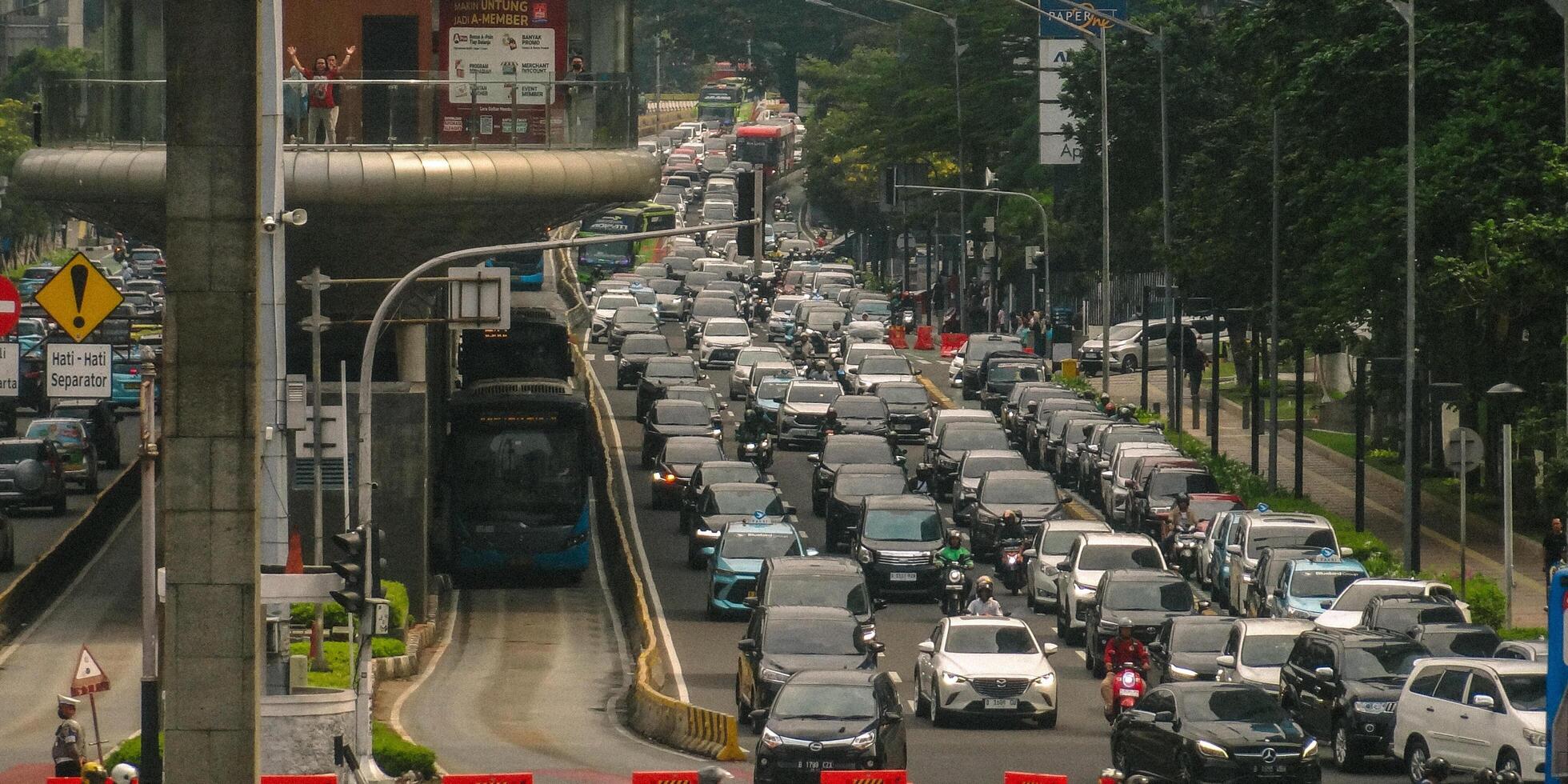A busy street with many cars and buses photo