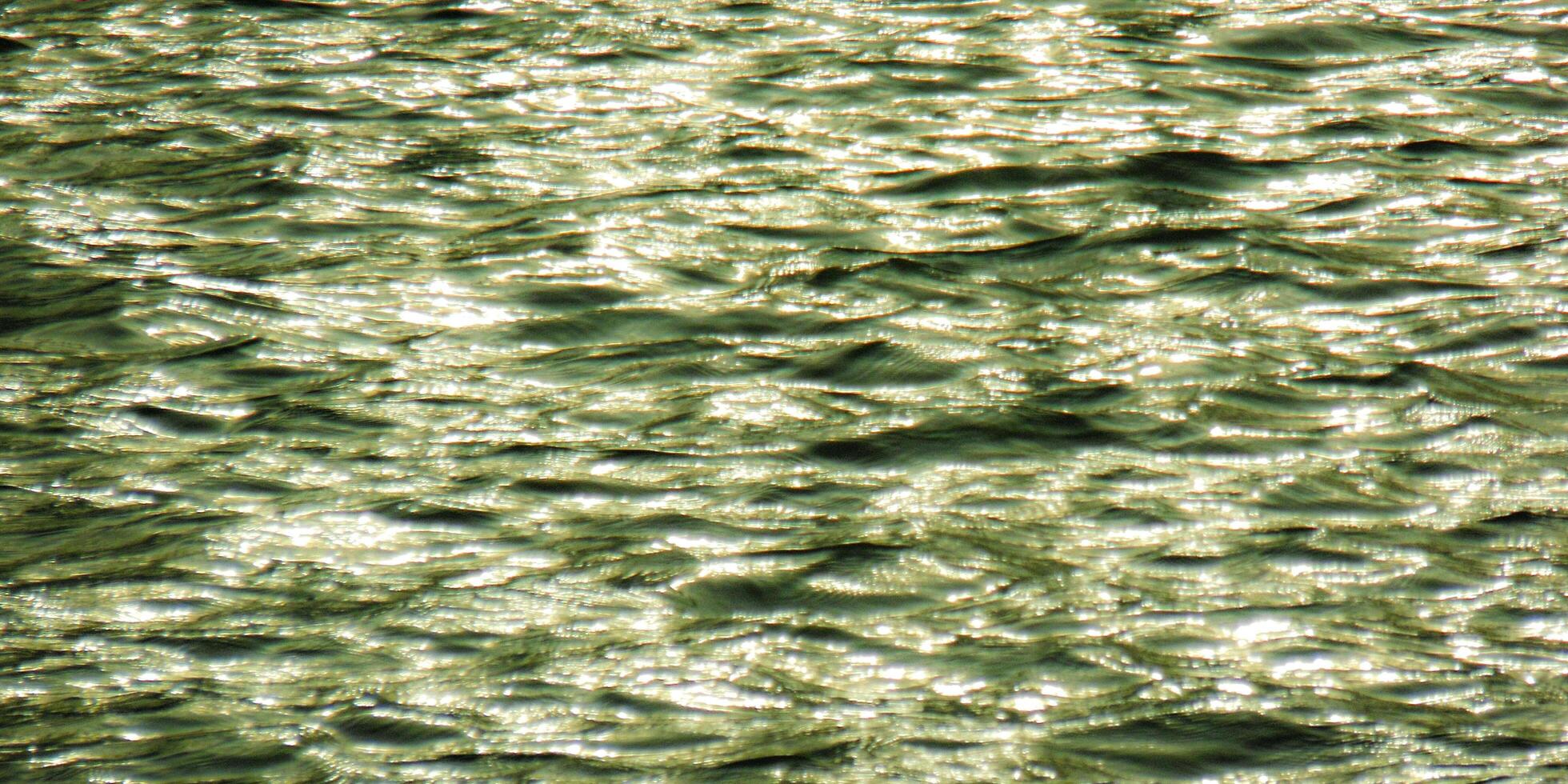 A close up of water with a reflection of the sun photo