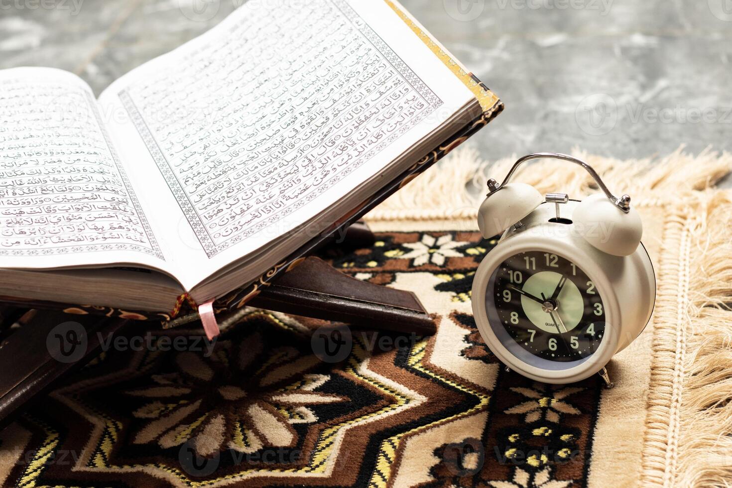 Islamic Holy Book Quran with alarm clock Ramadan Concept. photo
