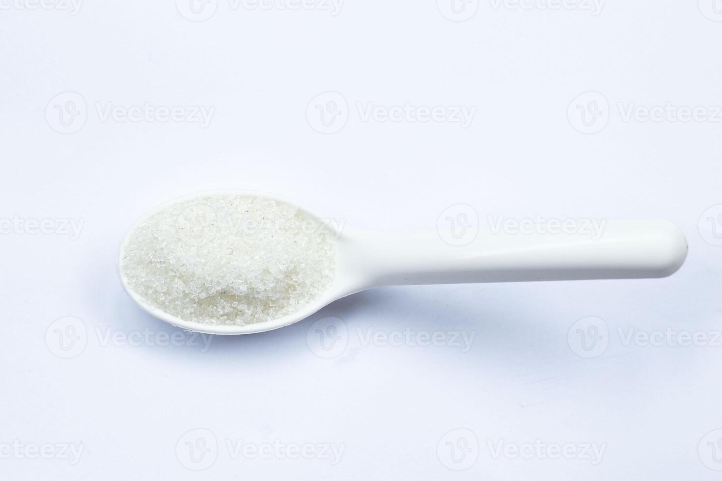 One teaspoon of sugar on a white background isolated top view photo