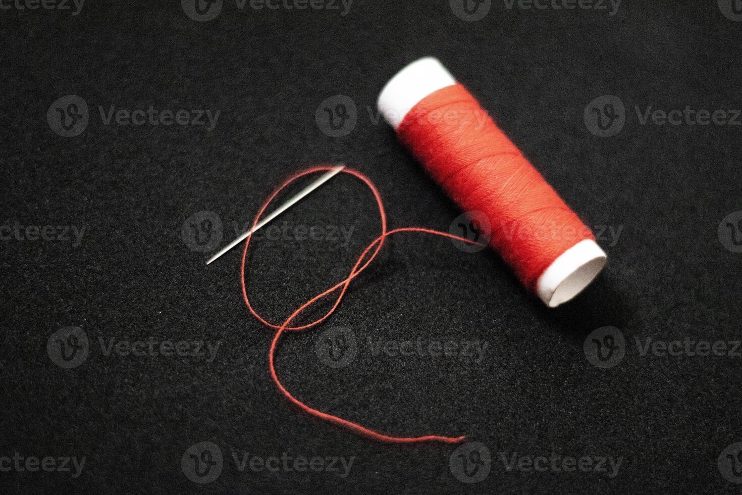 spool of thread with a needle on black isolated background photo