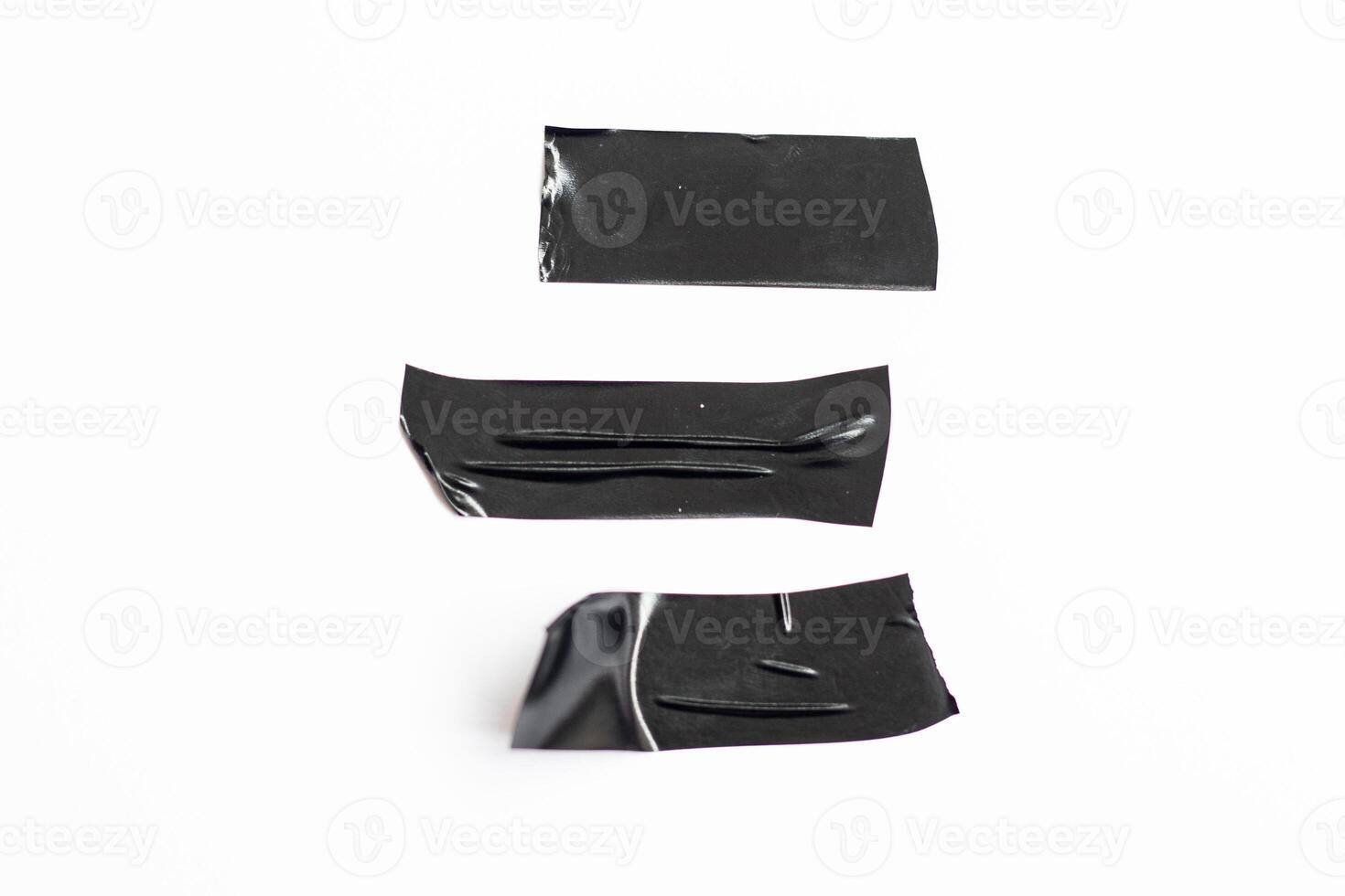 Piece of torn black ribbon isolated on white background. A set of crushed plastic adhesive tape photo