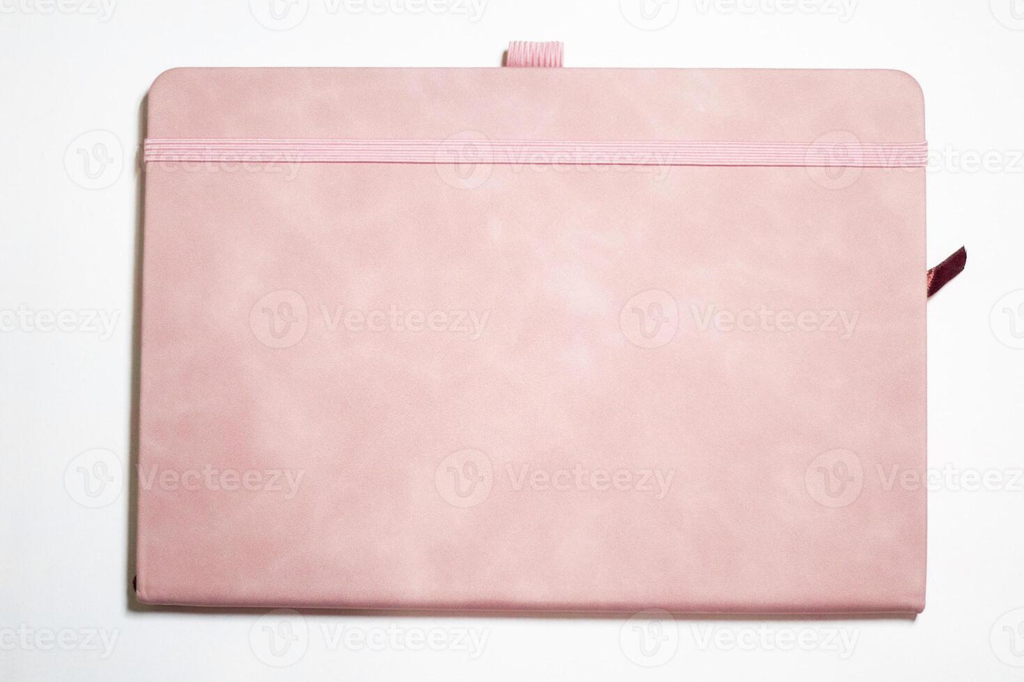 Closed pink empty square book mockup on white textured paper background. photo