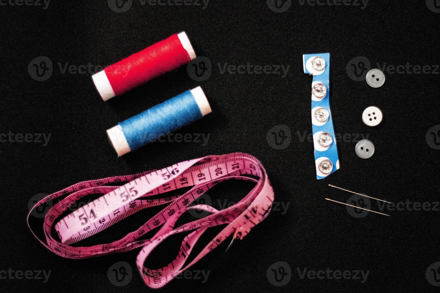 Sewing accessories on white background. Sewing thread, needle, pins, fabric, buttons and sewing centimeter. top view, flatlay photo
