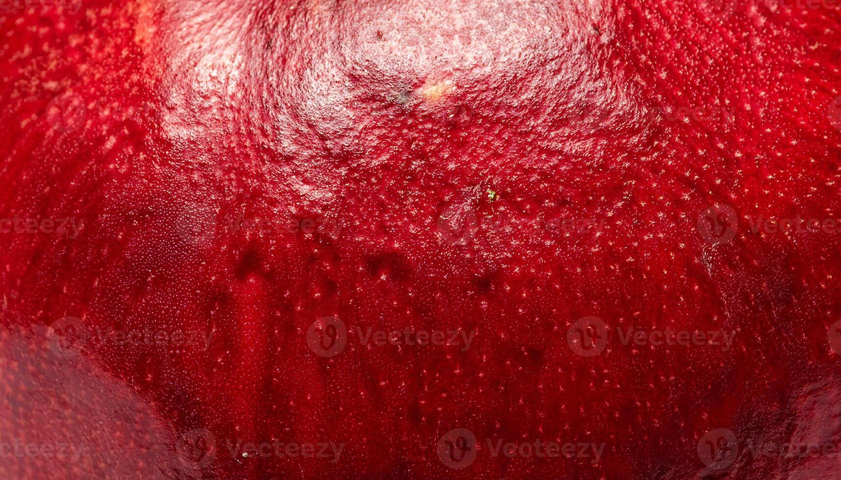 macro close-up of pomegranate peel featuring its thick leathery red texture and glossy surface details photo