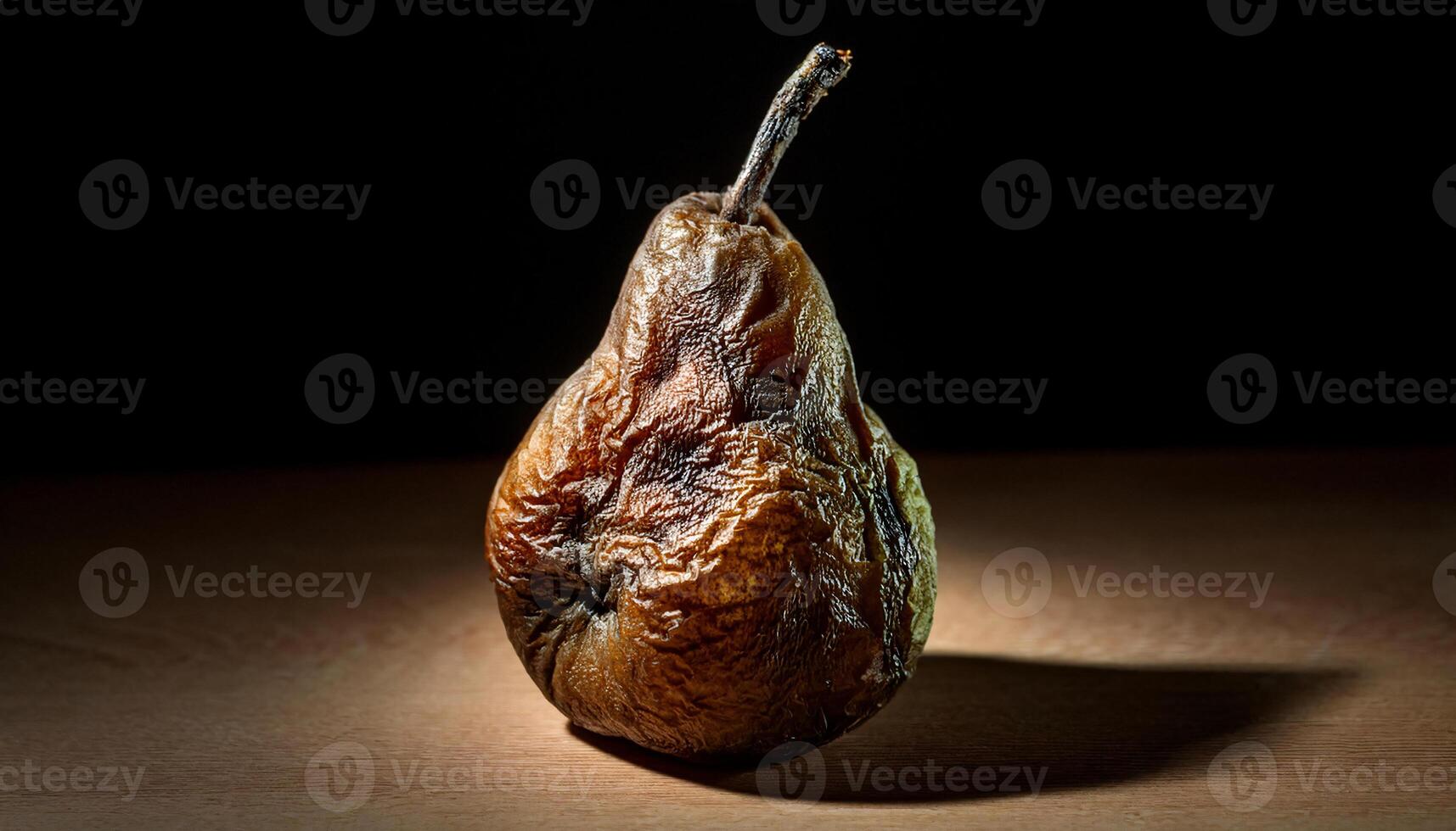 detailed shot of a rotting pear with wrinkled surface and fungal growth forming under dramatic lighting photo