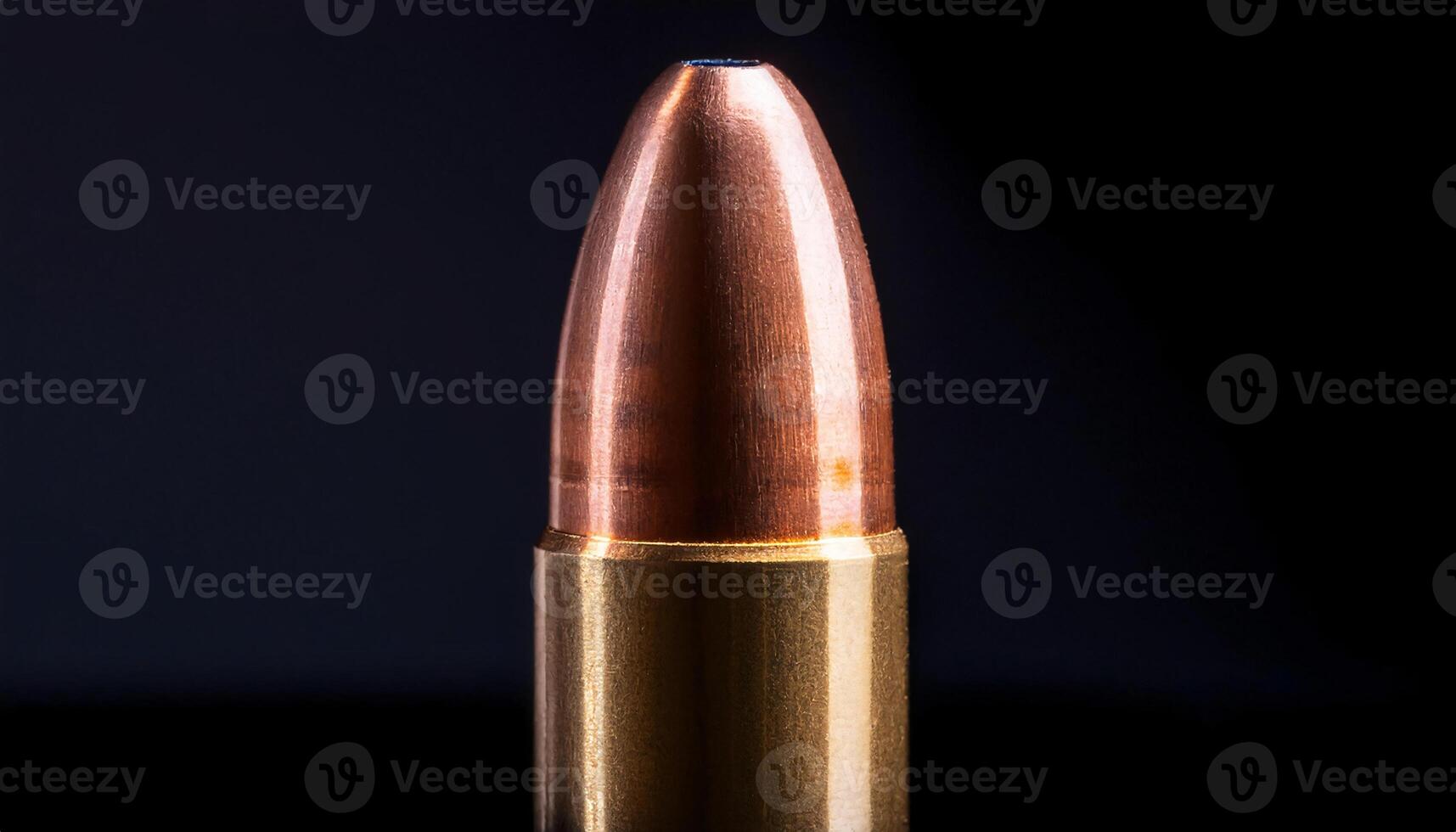 macro close-up of a single copper-tipped bullet casing standing upright with reflective metallic surface on a black background photo