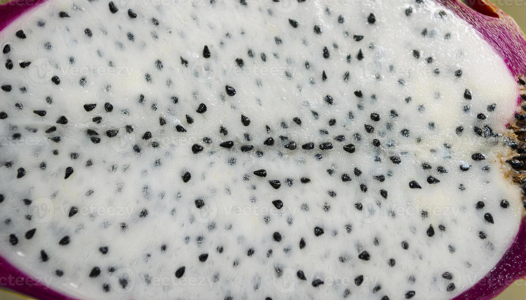 close-up of dragon fruit pulp with vibrant white flesh and scattered black seeds, tropical exotic fruit texture photo