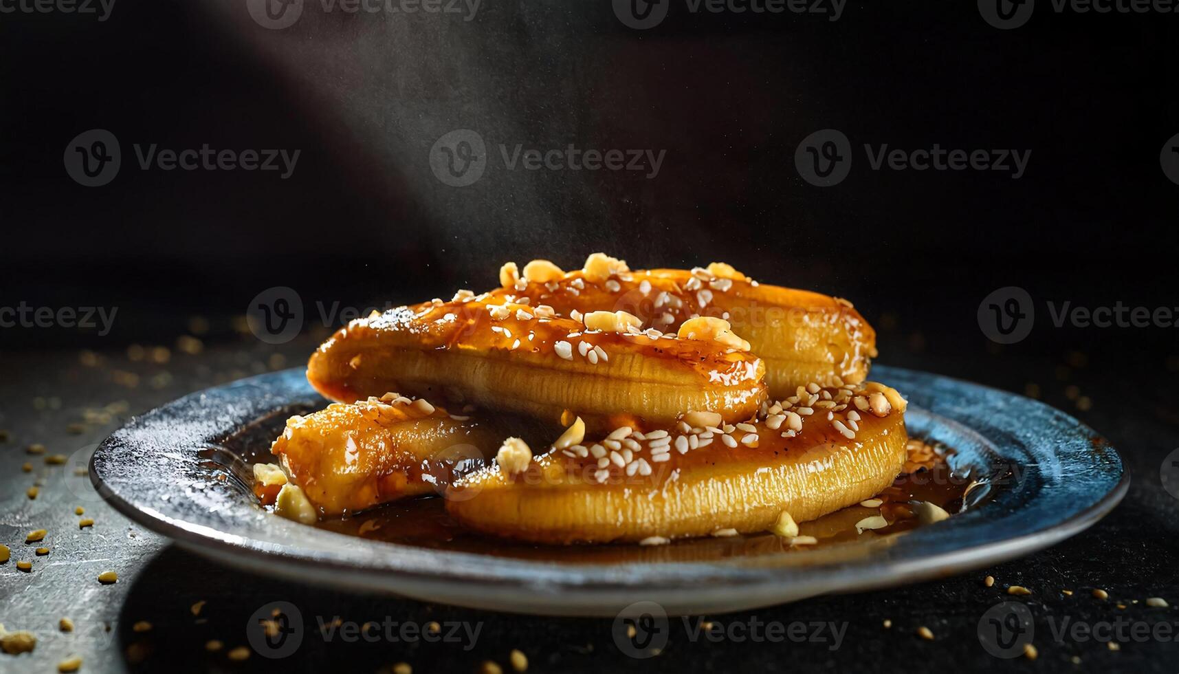 steaming plate of caramelized bananas drizzled with syrup and topped with crushed peanuts and sesame seeds photo