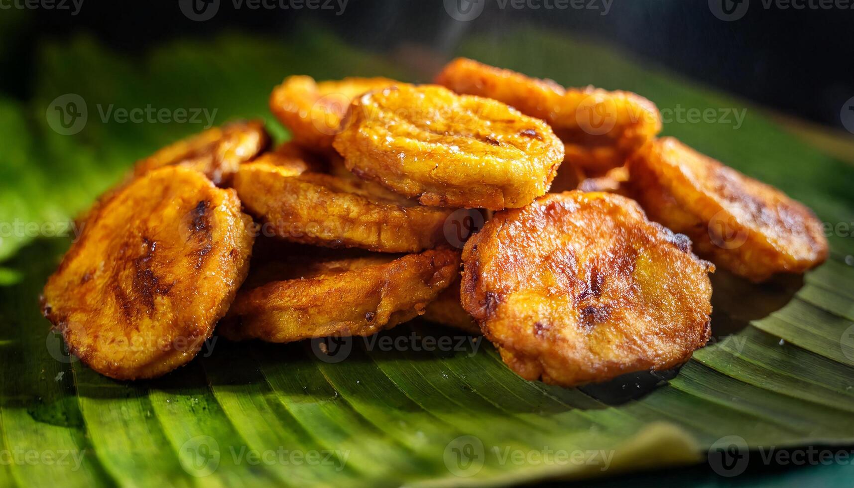 close-up of crispy golden fried plantains served hot on fresh banana leaf, traditional tropical snack with rich caramelized texture photo