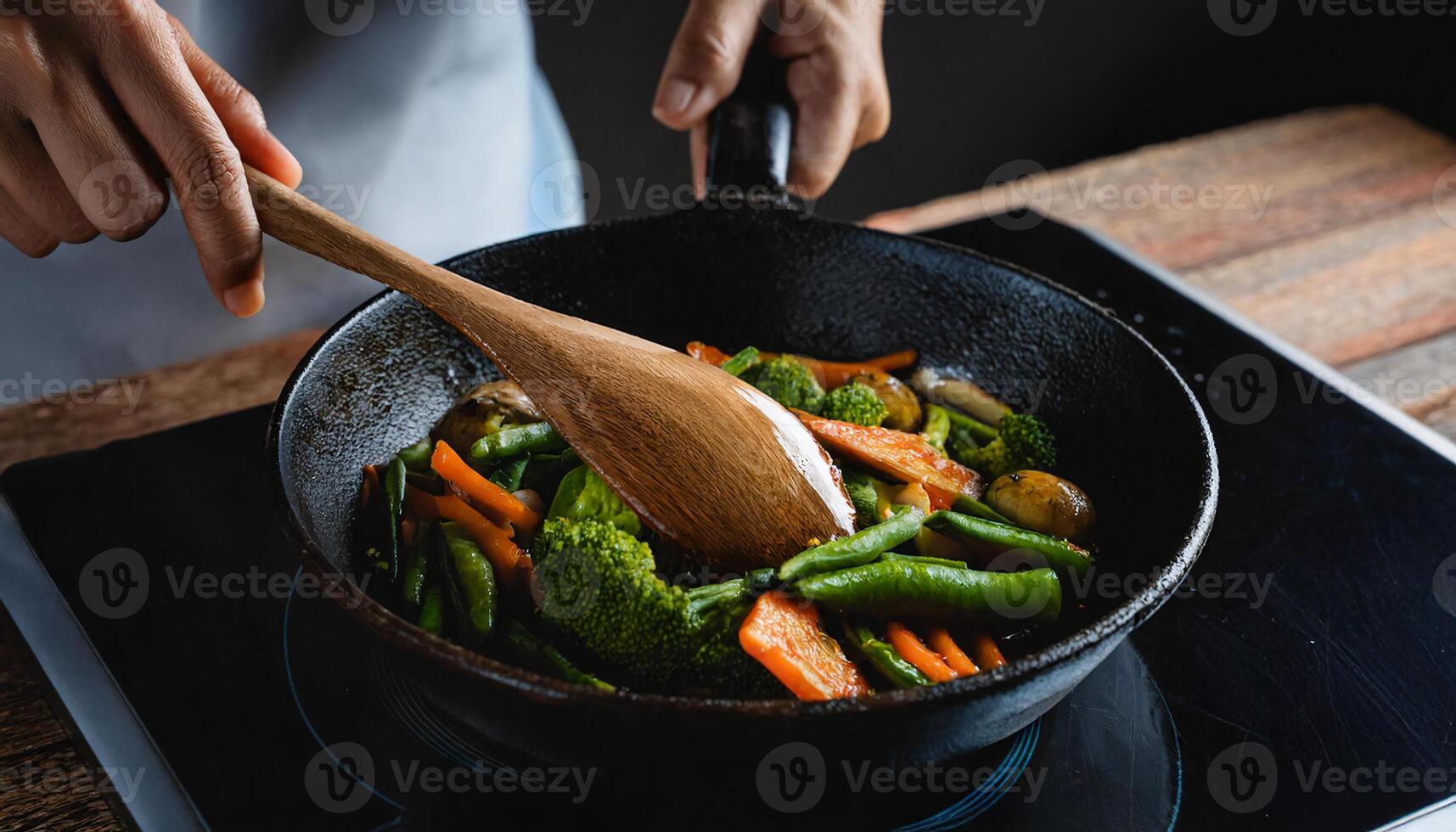 close-up of a chef hands gripping a cast-iron skillet while sauteing colorful vegetables on a rustic wooden surface photo