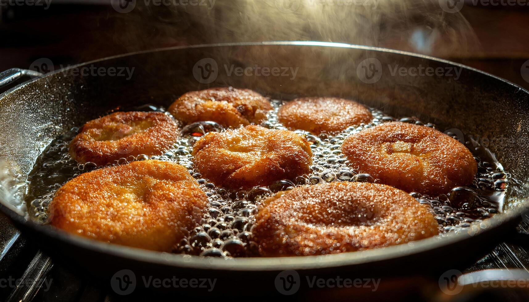 close-up of golden banana fritters frying in bubbling hot oil with crispy edges in a pan under the heat and steam rising photo