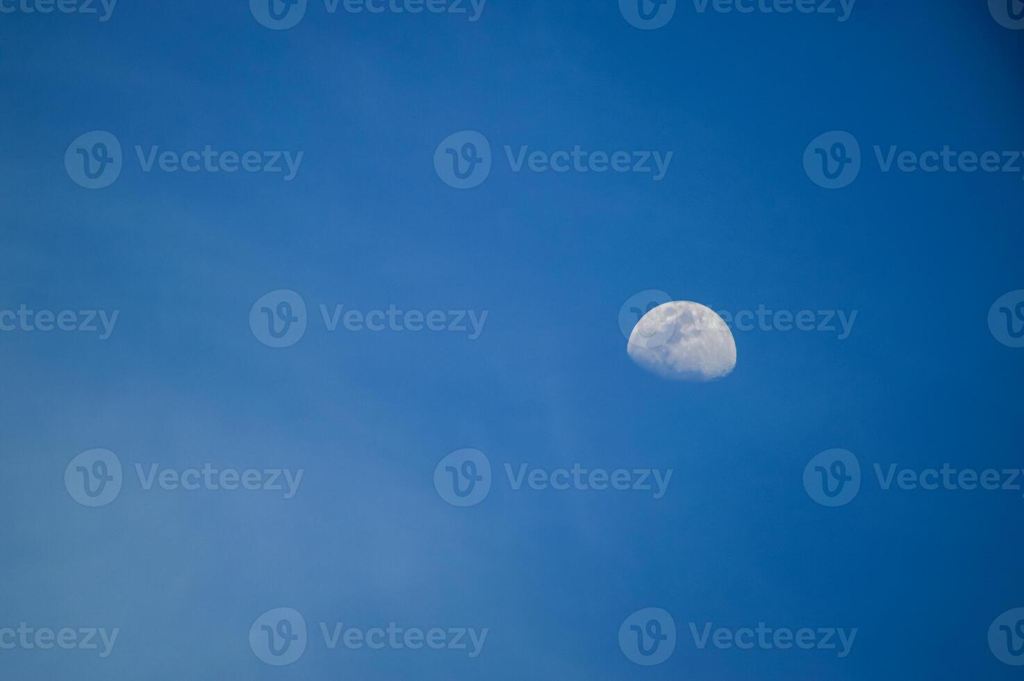 Half moon with blue sky and clouds background during the day. Blue sky background. photo