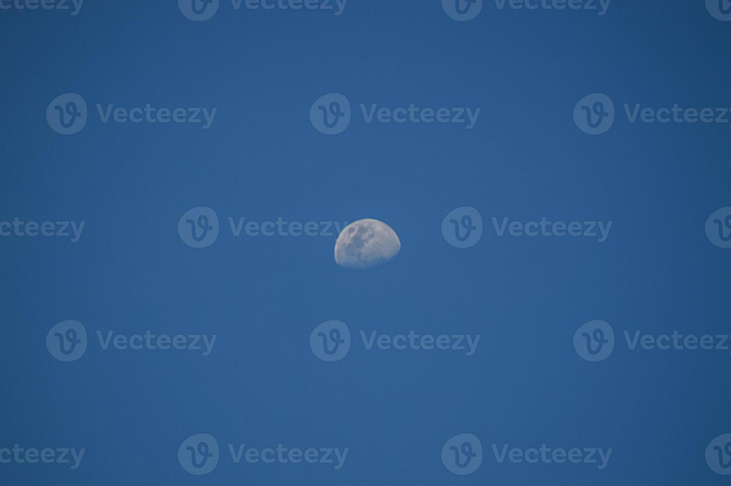Half moon with blue sky and clouds background during the day. Blue sky background. photo