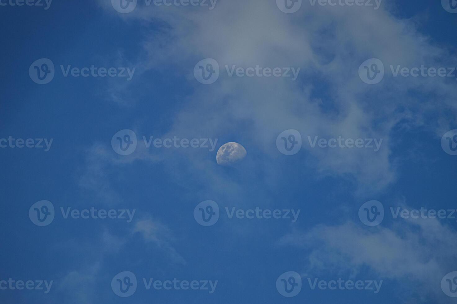 Half moon with blue sky and clouds background during the day. Blue sky background. photo