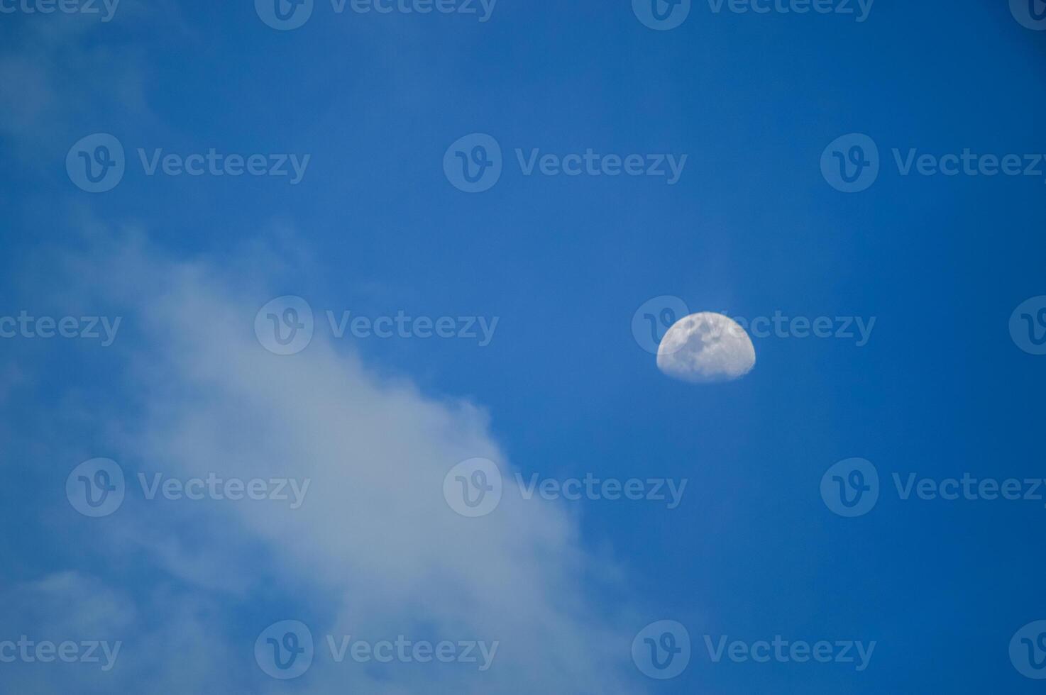Half moon with blue sky and clouds background during the day. Blue sky background. photo