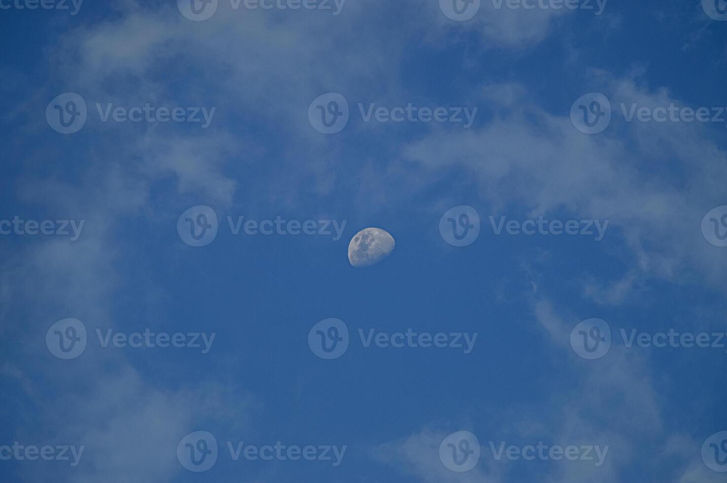 Half moon with blue sky and clouds background during the day. Blue sky background. photo
