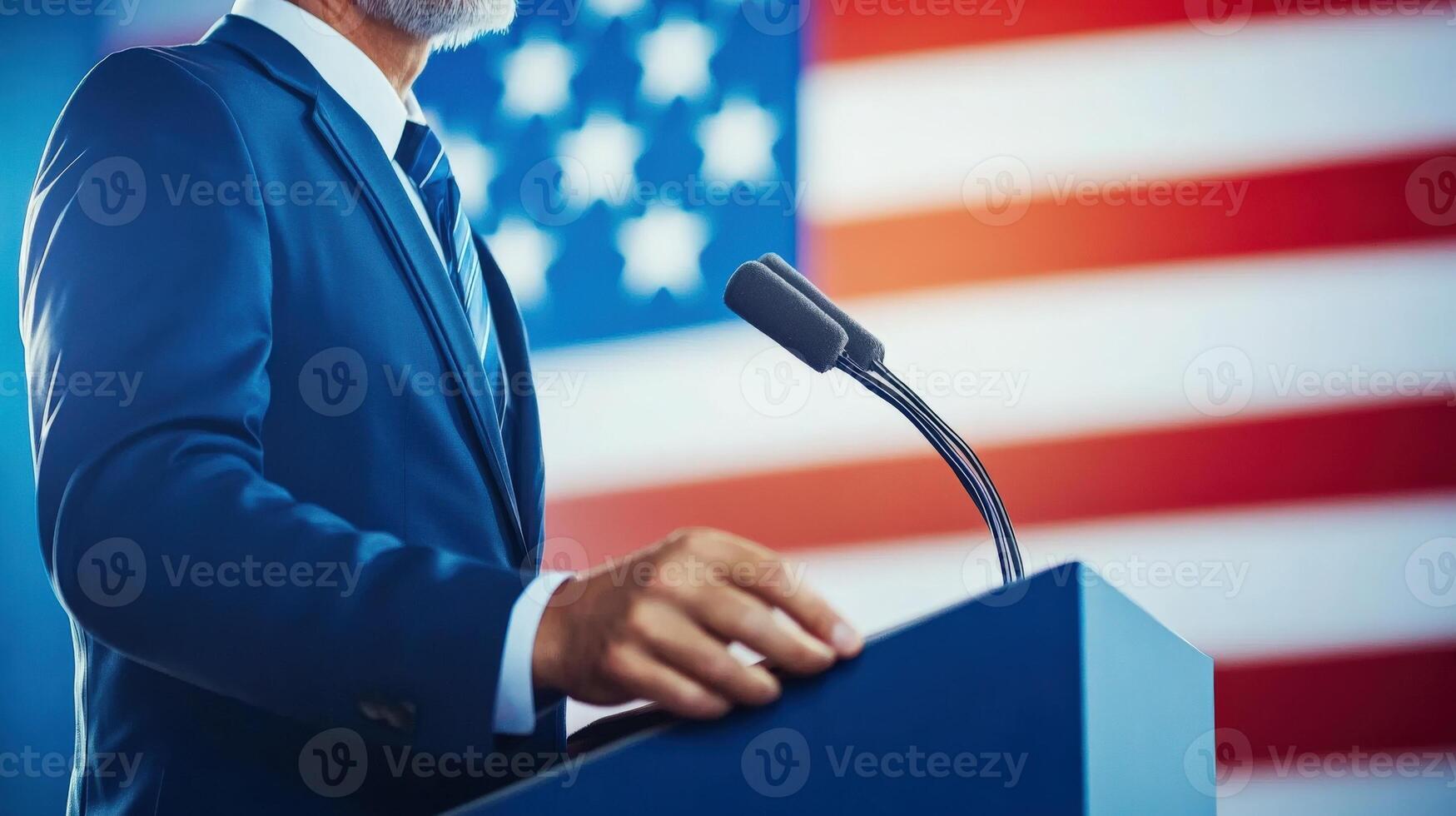 A confident speaker stands before an American flag at a podium during a public address. photo
