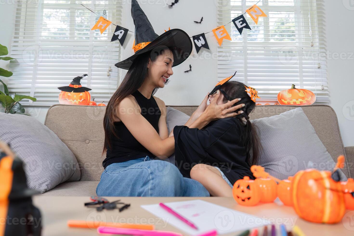 Mother and Daughter Enjoying Halloween Activities Together at Home with Costumes and Decorations photo