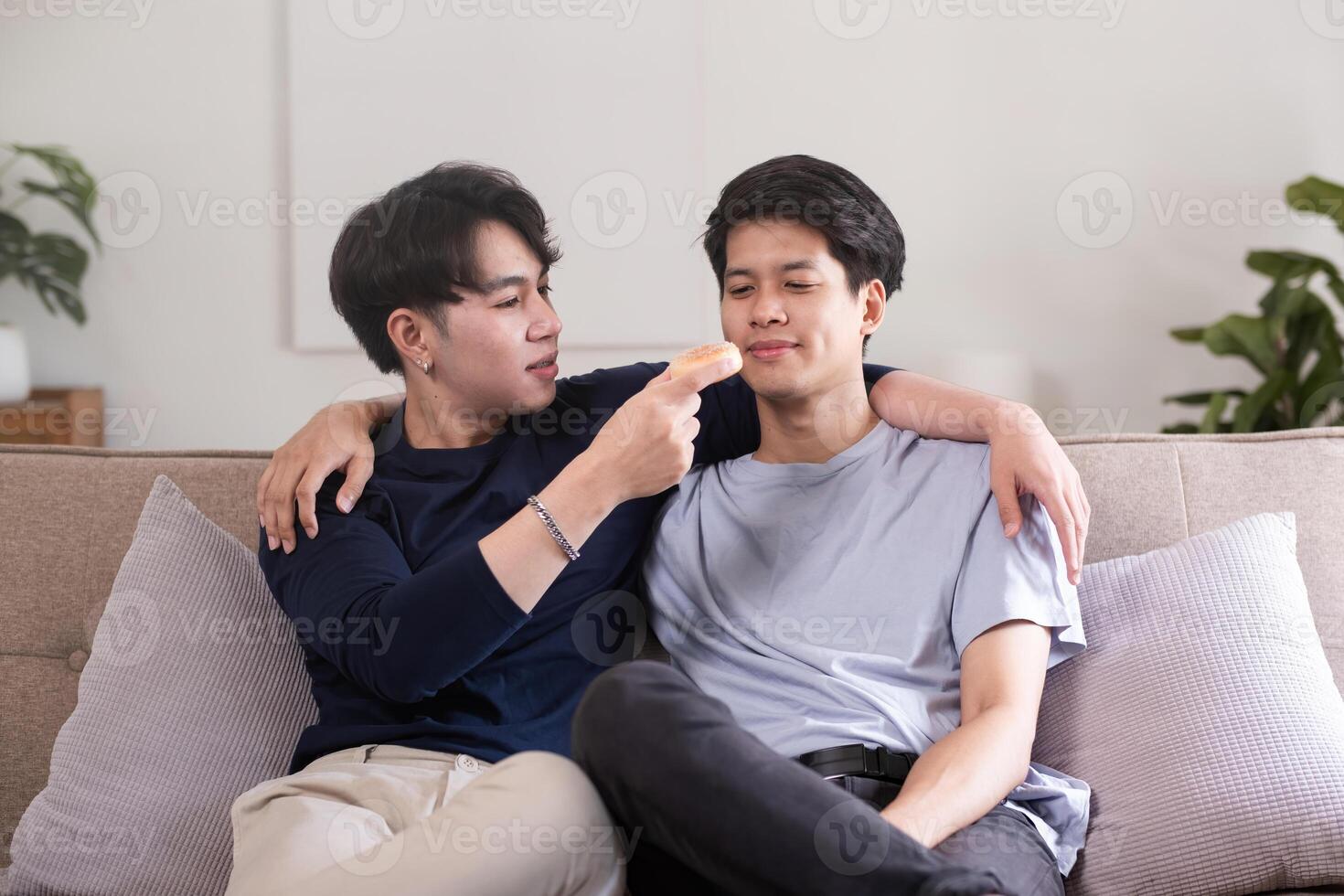 A male-male couple spends their free time happily doing holiday activities together, embracing each other and taking selfies together in the living room. photo