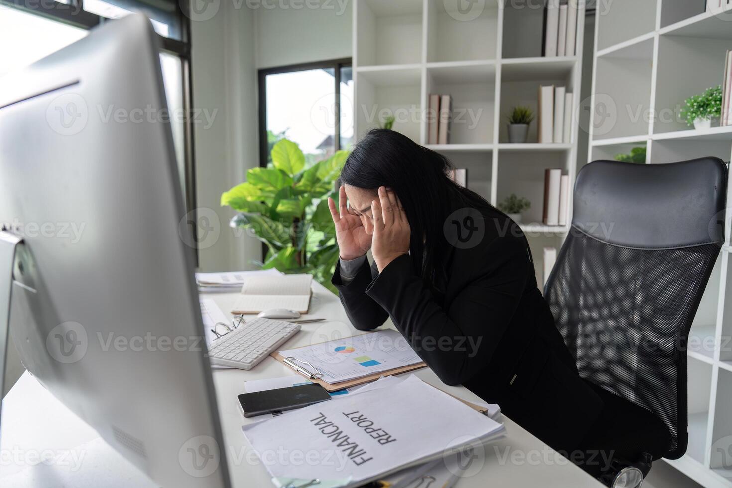 Stressed Business Woman Working at Computer Desk in Modern Office with Financial Reports and Documents photo
